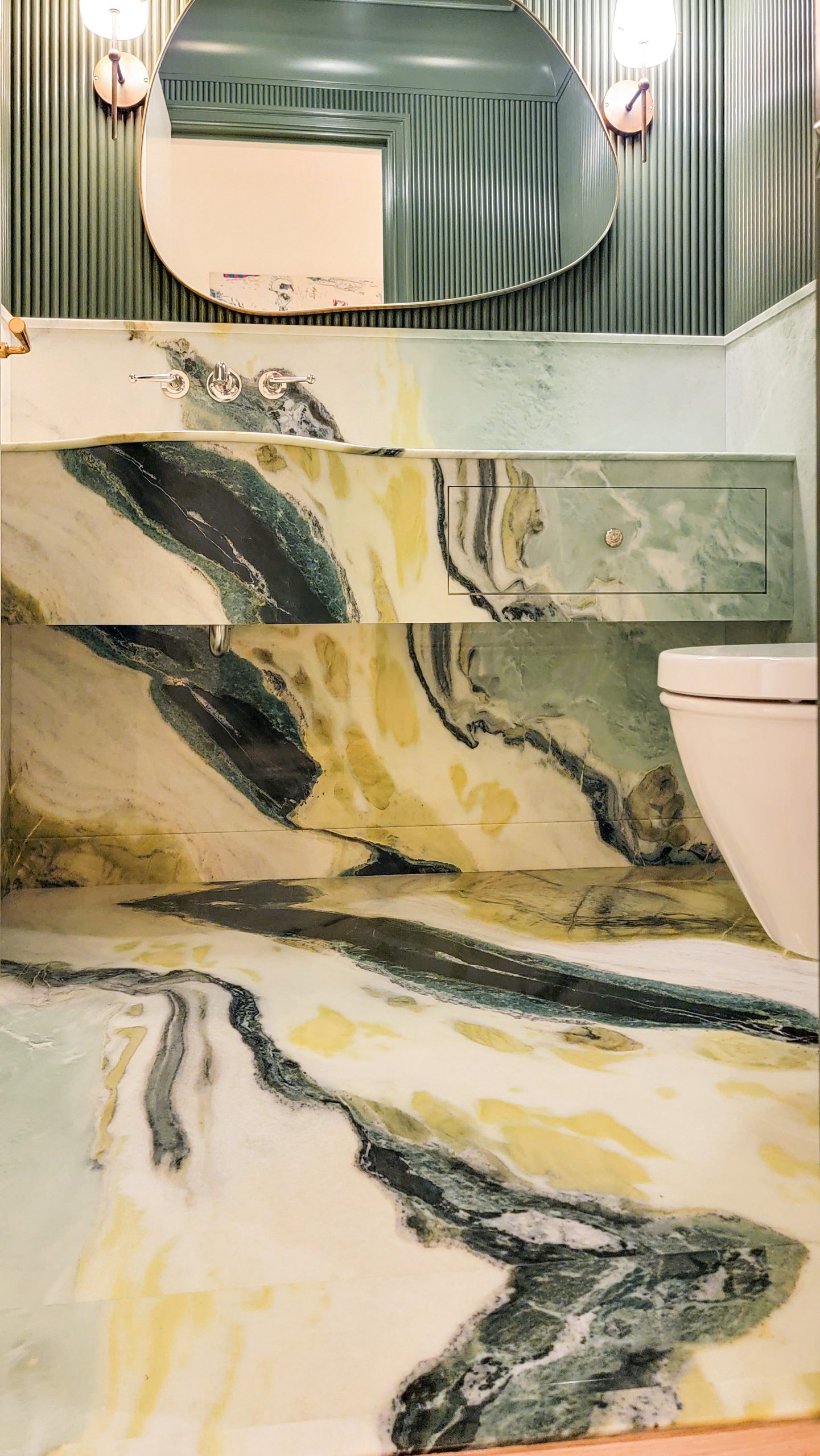 Dreaming Green marble floor, wall panels, and custom vanity with matched natural veining