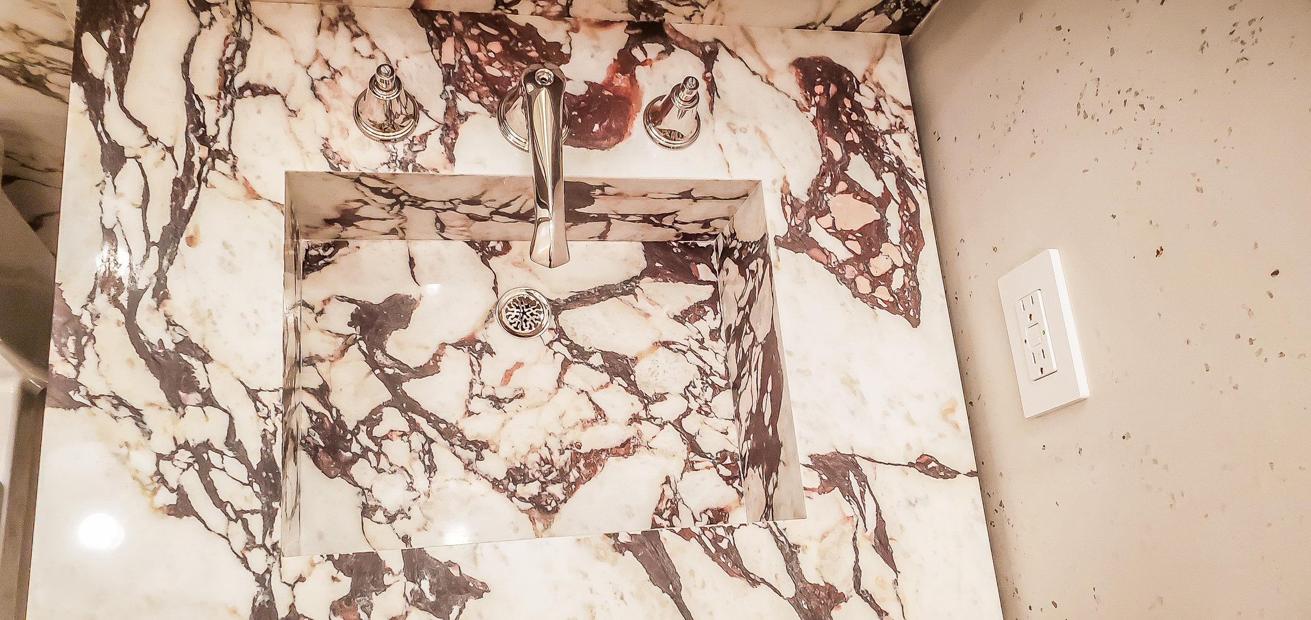 Top view of a custom mitered Calacatta Viola marble integrated bathroom sink